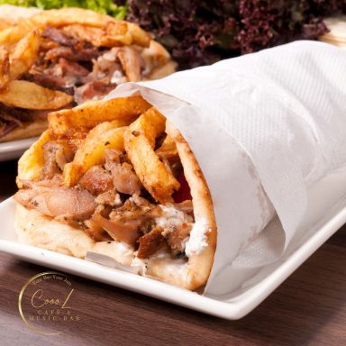 Leckeres Döner-Gericht mit Fleisch, Pommes und frischem Gemüse in einem Pita-Brot.