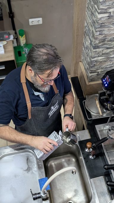 Ein Barista bereitet Kaffee in einer modernen Kaffeebar.